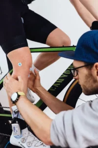 Nahaufnahme beim Bikefitting: Ein Sensor wird am Bein am Zeitfahrrad angebracht