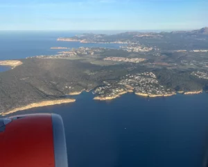 Blick aus dem Flugzeugfenster auf eine Küste und das Meer bei der Anreise zum Trainingslager
