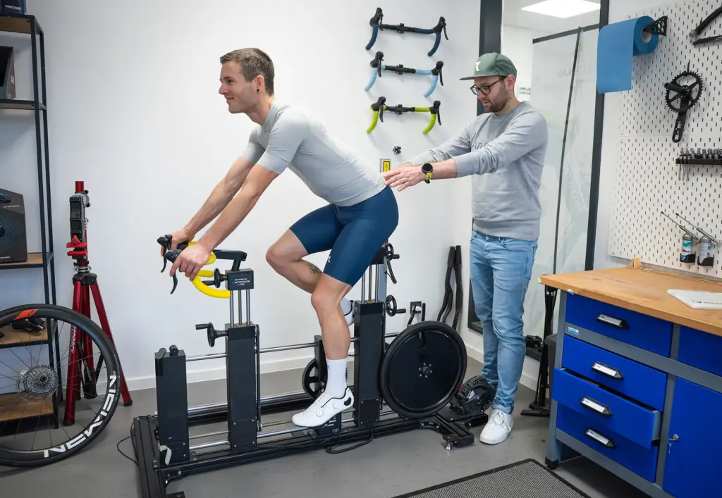 Radfahrer auf dem SizeCycle, ein Berater justiert die Position