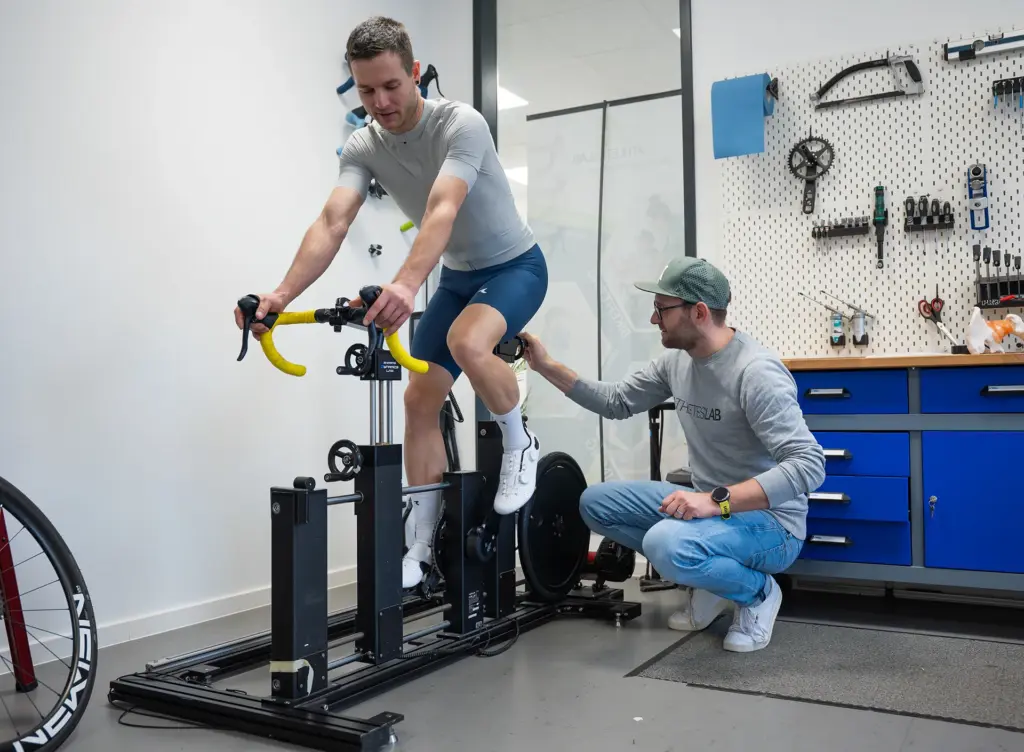 Radfahrer testet die Geometrie auf dem verstellbaren SizeCycle, ein Berater stellt ein