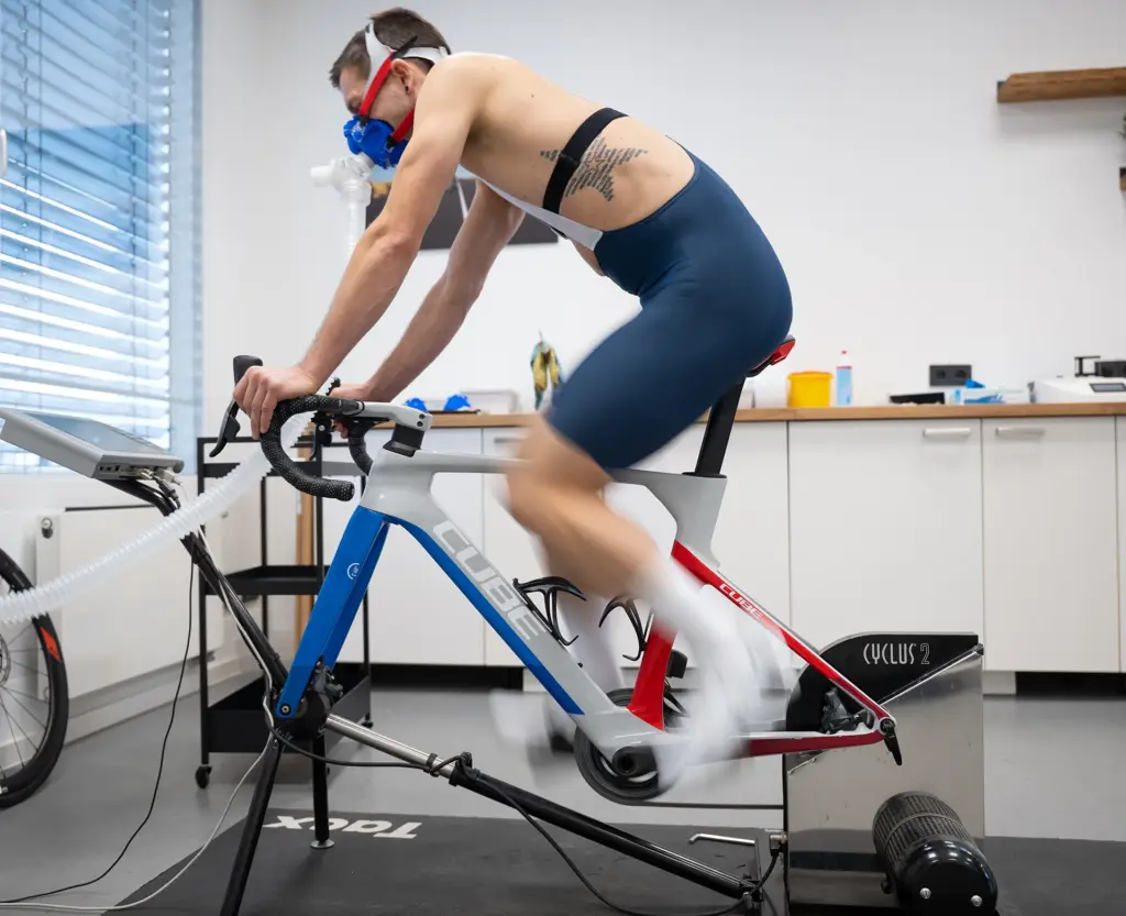 Triathlet auf dem Zeitfahrrad mit Atemmaske bei der Leistungsdiagnostik